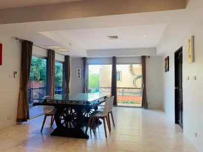 a dining room with a ping pong table and chairs at Rawai Condominium By Wijitra in Phuket Town