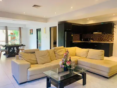 a living room with a couch and a table at Rawai Condominium By Wijitra in Phuket Town