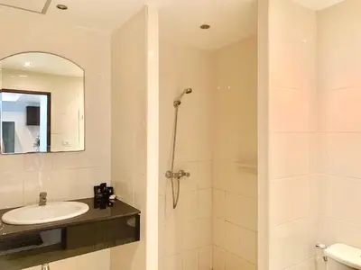 a white bathroom with a sink and a shower at Rawai Condominium By Wijitra in Phuket Town