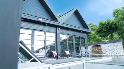 a house with windows and chairs on a patio at Jaokhun Hilltop Kamala, Phuket in Kamala Beach