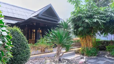 a house with a palm tree in front of it at Jaokhun Hilltop Kamala, Phuket in Kamala Beach