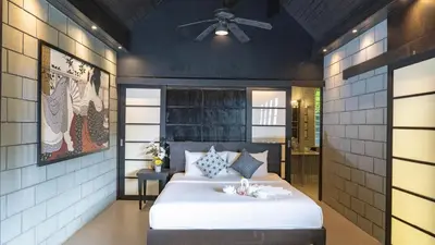a bedroom with a bed and a ceiling fan at Jaokhun Hilltop Kamala, Phuket in Kamala Beach