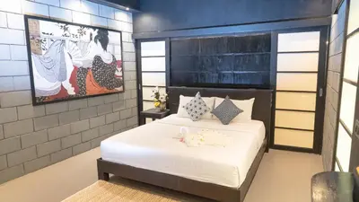 a bedroom with a bed with white sheets and pillows at Jaokhun Hilltop Kamala, Phuket in Kamala Beach