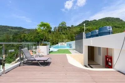 a balcony with a chair and a swimming pool at Fantasea Condo Kamala B204 2BDRM by Phuket Sabay Rent in Kamala Beach