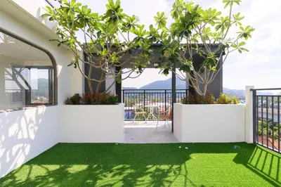 a room with a balcony with green grass and plants at Fantasea Condo Kamala B204 2BDRM by Phuket Sabay Rent in Kamala Beach