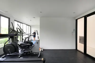 a gym with cardio machines and a woman in the background at Fantasea Condo Kamala B204 2BDRM by Phuket Sabay Rent in Kamala Beach