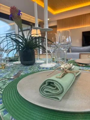 a table with a green napkin and glasses on it at MANDLA VILLAS COLLECTION, White Anda Naiharn in Rawai Beach