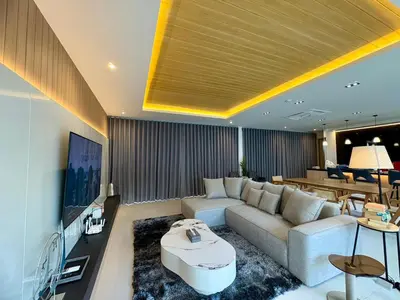 a living room with a couch and a tv at MANDLA VILLAS COLLECTION, White Anda Naiharn in Rawai Beach