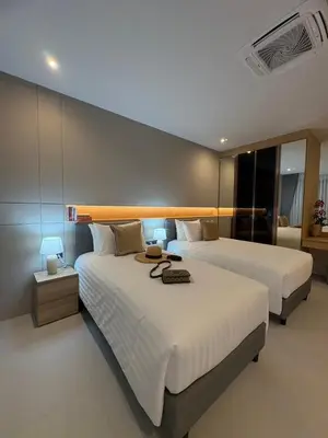 two beds in a hotel room with two lamps at MANDLA VILLAS COLLECTION, White Anda Naiharn in Rawai Beach