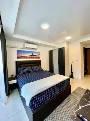 a bedroom with a bed with blue and white sheets at Palm Breeze View in Ban Mai Salae
