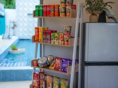 a shelf with food on it next to a refrigerator at Elegant 4BR Villa with Pool2 in Ban Bang La