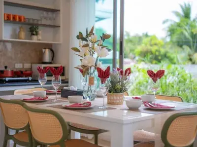 a table with chairs and vases with flowers on it at Elegant 4BR Villa with Pool2 in Ban Bang La