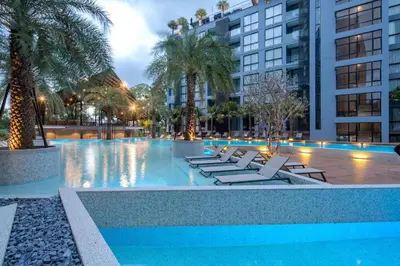 a swimming pool with lounge chairs and palm trees at Enjoy Tropical Bliss in Kamala Pool View Suite CTG P204, Top Facilities, near FantaSea & Café Del Mar Beach Club in Kamala Beach