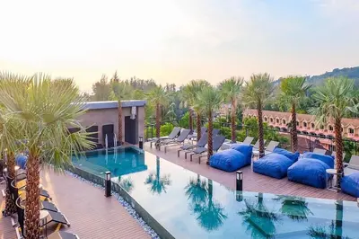 a resort with a swimming pool with palm trees at Enjoy Tropical Bliss in Kamala Pool View Suite CTG P204, Top Facilities, near FantaSea & Café Del Mar Beach Club in Kamala Beach