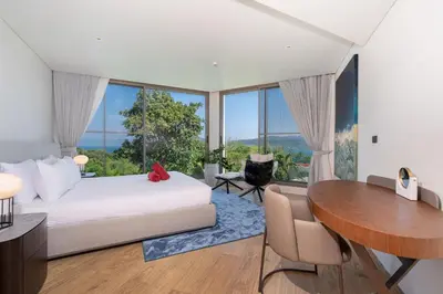 a bedroom with a bed and a desk and a table at Sea Views 2BR ,,Adult Only,, Apartment 817 in Sapphire Bay Residence, Patong in Patong Beach