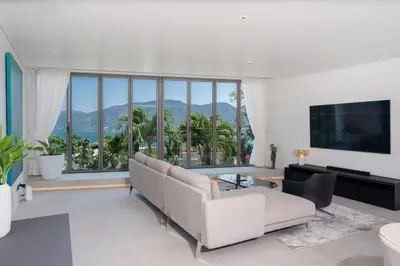 a living room with a couch and a large window at Sea Views 2BR ,,Adult Only,, Apartment 817 in Sapphire Bay Residence, Patong in Patong Beach