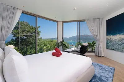a bedroom with a large white bed and large windows at Sea Views 2BR ,,Adult Only,, Apartment 817 in Sapphire Bay Residence, Patong in Patong Beach