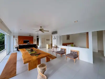 a living room with a wooden table and chairs at Peaceful The Trees Kamala Hillside in Kamala Beach