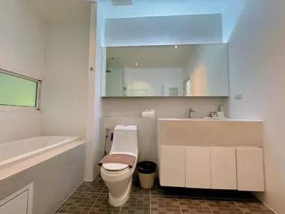 a bathroom with a toilet and a sink and a mirror at Peaceful The Trees Kamala Hillside in Kamala Beach