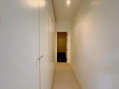 a hallway with a white wall and a door at Peaceful The Trees Kamala Hillside in Kamala Beach