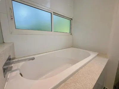 a white bath tub in a bathroom with a window at Peaceful The Trees Kamala Hillside in Kamala Beach