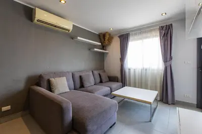 a living room with a couch and a table at Modern Condo - 1BR T1 -501 in Chalong