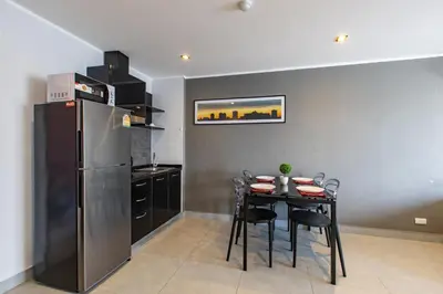a kitchen with a table with chairs and a refrigerator at Modern Condo - 1BR T1 -501 in Chalong