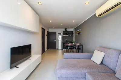 a living room with a couch and a flat screen tv at Modern Condo - 1BR T1 -501 in Chalong