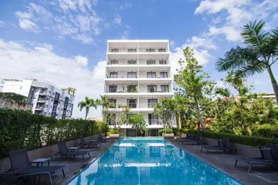 a hotel swimming pool with chairs and a building at Cozy Apartment-1BR T2-524 in Chalong