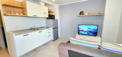 a kitchen with a couch and a tv on a wall at Cozy Apartment-1BR T2-524 in Chalong