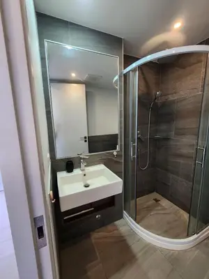 a bathroom with a sink and a shower with a mirror at Cozy Apt-1BR T3-635 in Chalong