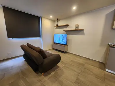 a living room with a couch and a flat screen tv at Cozy Apt-1BR T3-635 in Chalong
