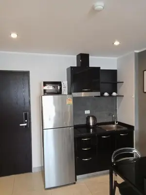 a kitchen with a stainless steel refrigerator and black cabinets at Well located condo-1BR T1-NV-203 in Chalong