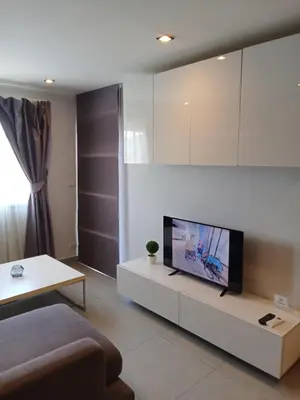 a living room with a flat screen tv on a table at Well located condo-1BR T1-NV-203 in Chalong