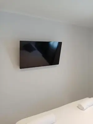 a flat screen tv hanging on a white wall at Well located condo-1BR T1-NV-203 in Chalong