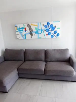 a couch in a living room with a painting on the wall at Ocean View Apt - 1BR T2-613 in Chalong
