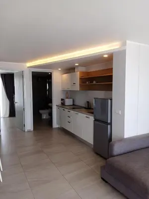 a kitchen with white cabinets and a black refrigerator at Ocean View Apt - 1BR T2-613 in Chalong