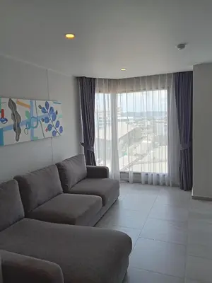a living room with a couch and a large window at Ocean View Apt - 1BR T2-613 in Chalong