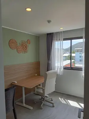 an office with a table and a chair and a window at Modern Condo - 1BR T3-528 in Chalong
