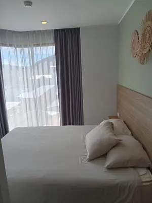 a bedroom with a large bed with a window at Modern Condo - 1BR T3-528 in Chalong