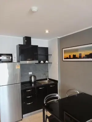 a kitchen with a stainless steel refrigerator and black cabinets at Modern Condo - 1BR T3-528 in Chalong