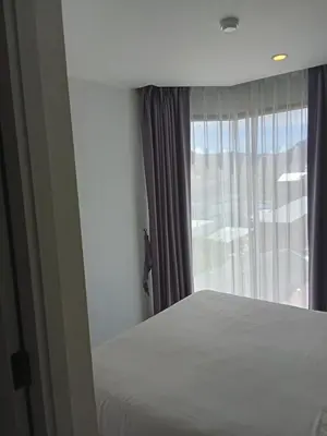 a bedroom with a bed and a window at Modern Condo - 1BR T3-528 in Chalong