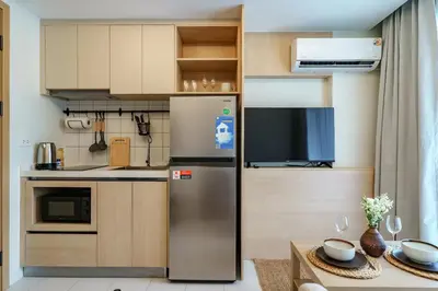 a kitchen with a refrigerator and a table at Cozy 1BdR Kamala Beach Pools on the Roof in Kamala Beach