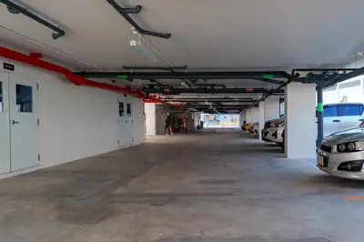 an empty garage with cars parked in it at Cozy 1BdR Kamala Beach Pools on the Roof in Kamala Beach