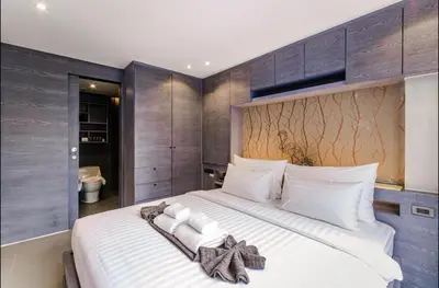 a bedroom with a large bed with towels on it at Citygate resort in Kamala Beach
