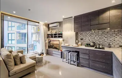 a living room with a couch and a kitchen at Citygate resort in Kamala Beach