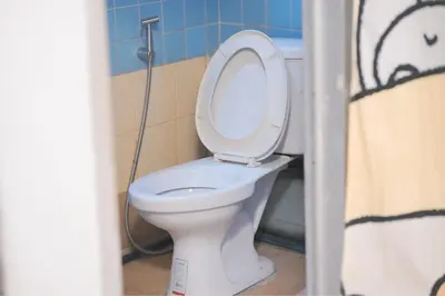 a bathroom with a toilet with the lid up at Comfort Hostel Phuket Old Town by MaTong in Phuket Town