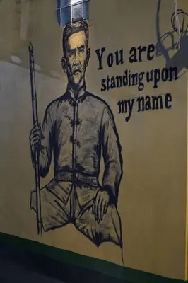 a drawing of a man holding a gun on a wall at Comfort Hostel Phuket Old Town by MaTong in Phuket Town