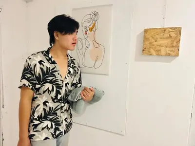 a man standing in front of a art exhibit at Comfort Hostel Phuket Old Town by MaTong in Phuket Town