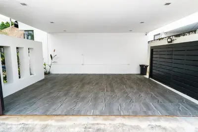 a large garage with a black garage door at Henia Villa by G Estate Phuket in Ban Saiyuan (1)